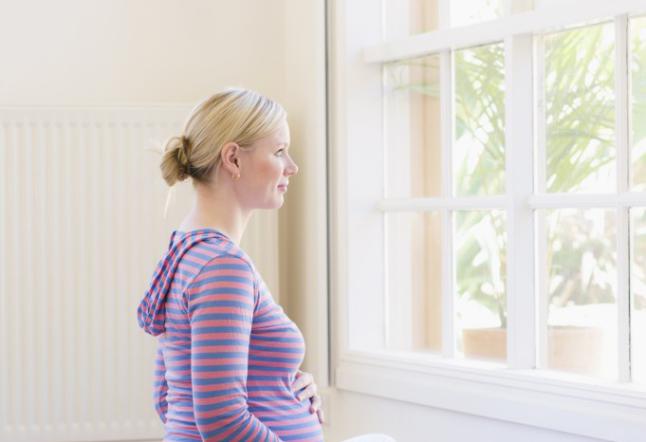 Pregnant woman sitting at window