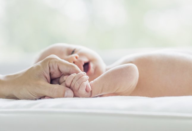 1 week old baby holding mother's hand