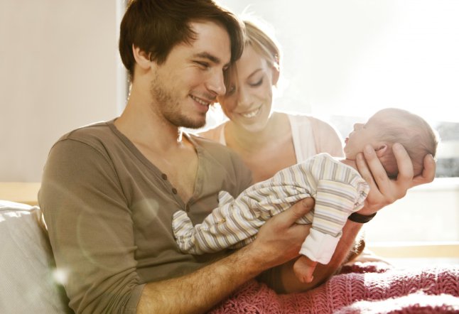 Parents with newborn baby at home