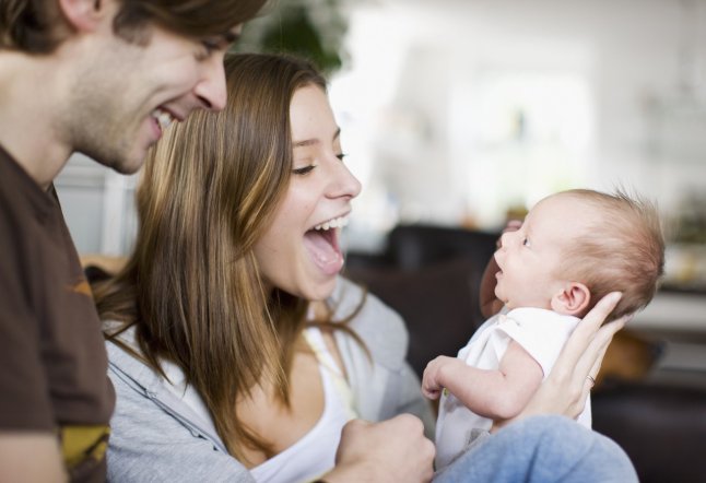 Couple smiling at newborn baby