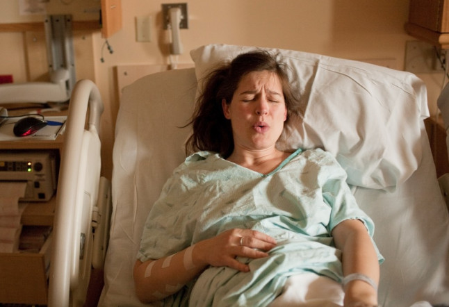 Pregnant woman in labor on hospital bed