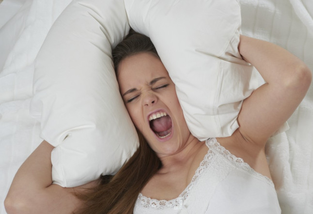 Woman lying on bed and screaming